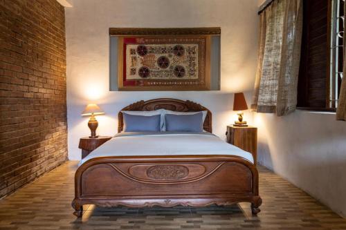 sypialnia z łóżkiem, 2 lampami i ścianą z cegły w obiekcie Nienté Bali w mieście Penebel