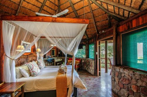 a bedroom with a canopy bed in a house at Shayamoya Tiger Fishing and Game Lodge in Pongola Game Reserve