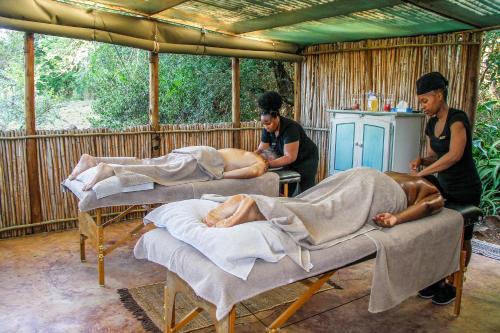 a group of men laying on beds in a room at Shayamoya Tiger Fishing and Game Lodge in Pongola Game Reserve