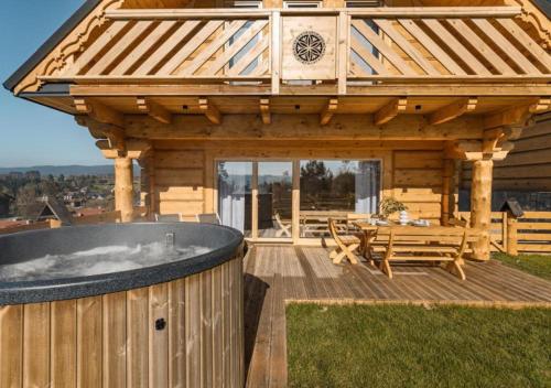 a wooden cabin with a hot tub on a deck at Pienińska Przystań in Kluszkowce