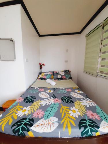 a bedroom with a bed with a colorful comforter at Subangan sa Adlaw 5 in Burgos