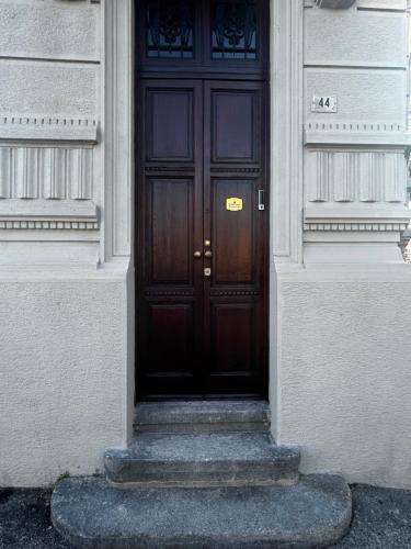 - une porte en bois dans un bâtiment avec des escaliers dans l'établissement Guest House Mameli44, à Busto Arsizio
