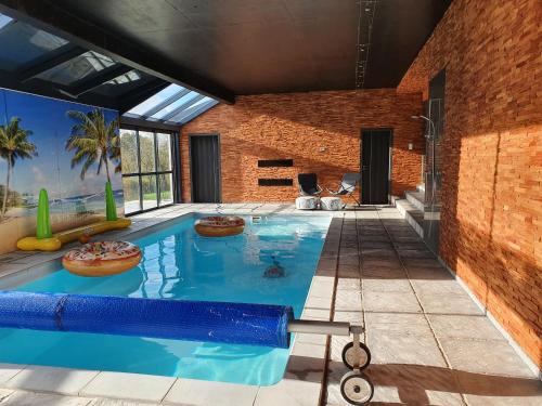 - une piscine dans un bâtiment avec piscine dans l'établissement Gite Le Gouttis, à Tellancourt