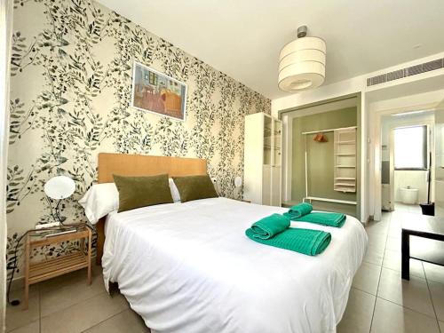 a bedroom with a large white bed with green sheets at Hispalis Gran Plaza in Seville