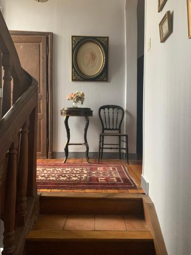 una escalera con una mesa y una silla en un pasillo en Le Relais, en Arnage