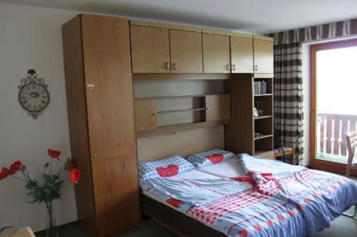 - une chambre avec un lit et une armoire intégrée dans l'établissement Ferienwohnpark Oberallgäu, à Missen-Wilhams
