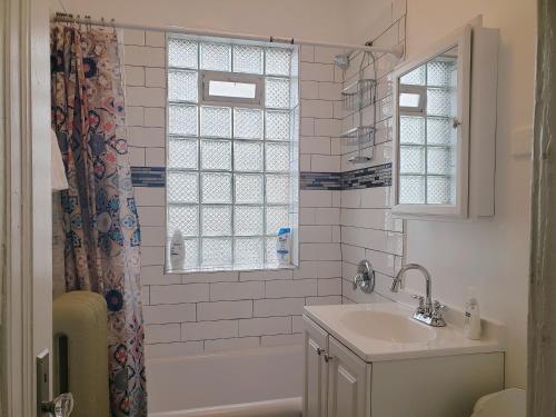 La salle de bains est pourvue d'un lavabo et d'un rideau de douche. dans l'établissement Classy Apt/Comfy Beds/25mins to ORD, MDW, DT, HOSP, à Berwyn