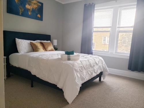 - une chambre avec un lit doté de draps blancs et une fenêtre dans l'établissement Classy Apt/Comfy Beds/25mins to ORD, MDW, DT, HOSP, à Berwyn