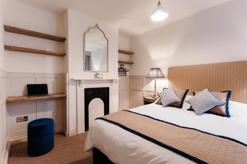 um quarto com uma cama grande e uma lareira em Didi's Cottage em Cowes