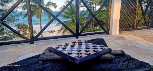 a chess board on a table in a room with a view of the beach at Ayla Beach House in Kiwengwa