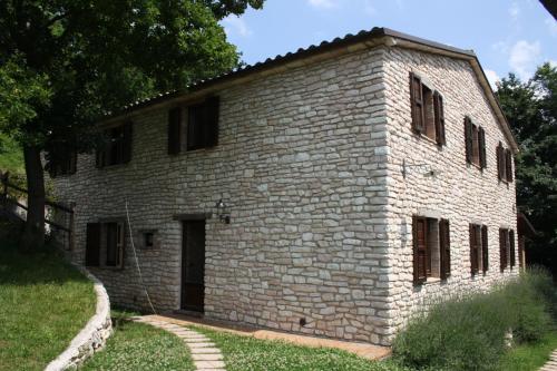 an old brick building with a door in a yard at Agriturismo Valdifiori in Sassoferrato