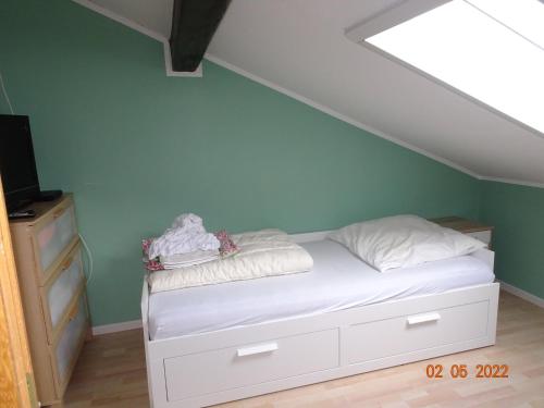 a bedroom with a bed with white sheets and a roof at Pension Anderl in Bodenmais