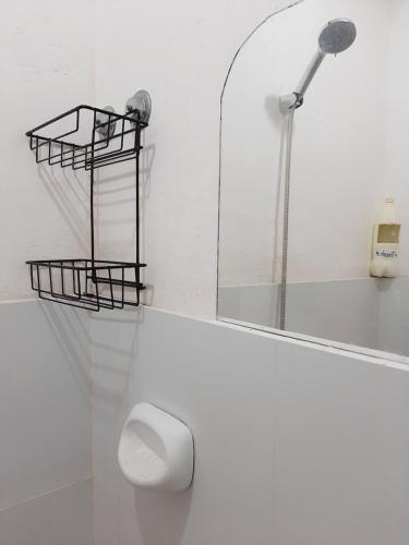 a white bathroom with a toilet and a mirror at Subangan Room 6 in Burgos