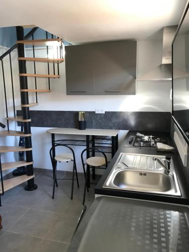 Il comprend une cuisine équipée d'un évier, d'une cuisinière et d'une table. dans l'établissement Jolie maisonnette, à Auxerre