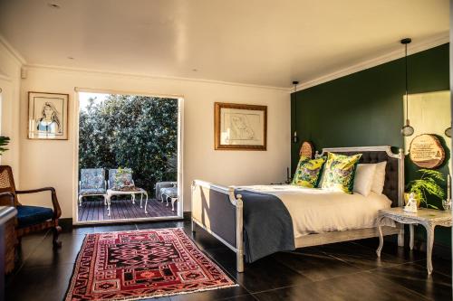 a bedroom with a bed with a green wall at Mettahouse in Cape Town