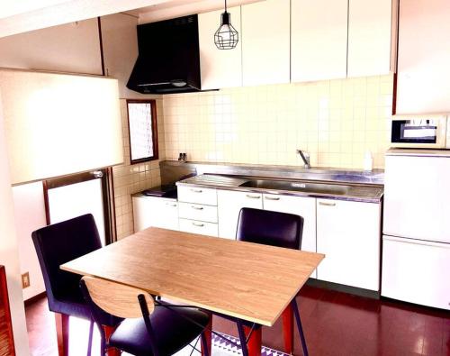 a kitchen with a wooden table and chairs at sonic apartment annex202　sonic hotelの離 ４名様まで同一価格 in Dazaifu