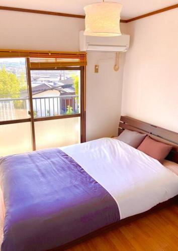 a bedroom with a large bed and a window at sonic apartment annex202　sonic hotelの離 ４名様まで同一価格 in Dazaifu