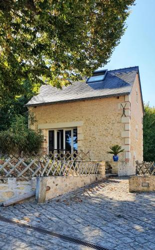 ein Haus mit einem Zaun davor in der Unterkunft Le Moulin de Follet in Fougeré