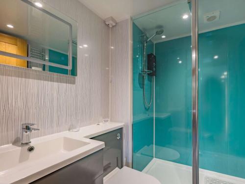 y baño con ducha acristalada y lavamanos. en 1 bed in Leominster 86883, 