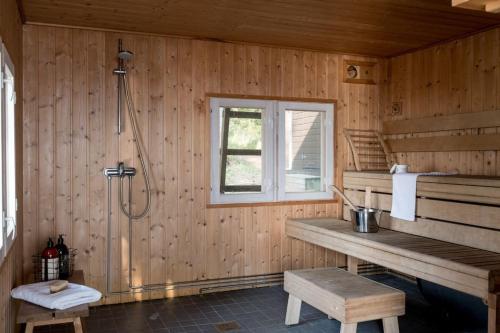 a bathroom with a shower and a bench and a window at Villa Merituuli - Charming Seafront Cottage in Porvoo