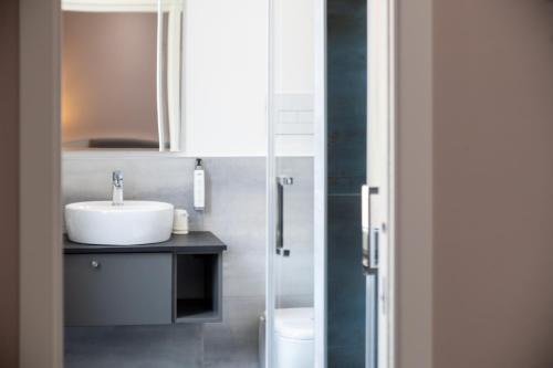 a bathroom with a sink and a glass shower at Palazzo Cappuccini Art Relais in Naples