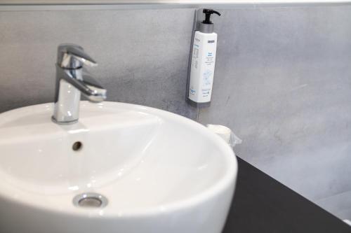 a white sink and a bottle of soap on a counter at Palazzo Cappuccini Art Relais in Naples