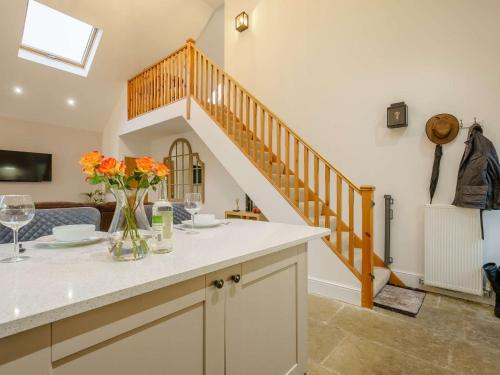 a kitchen with a staircase and a vase of flowers on a counter at 1 Bed in Bishop Auckland 86812 in Byers Green