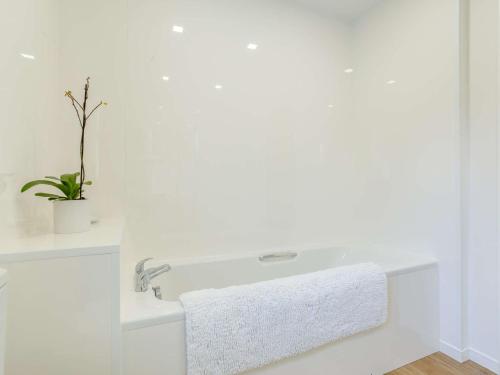 a white bathroom with a sink and a plant at 2 Bed in Camus Croise 86437 in Isleornsay