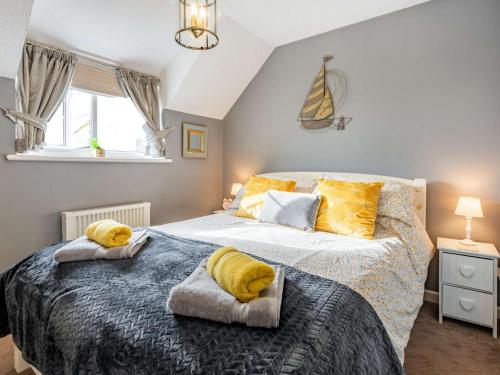 1 dormitorio con 1 cama grande con almohadas amarillas en 2 Bed in Bude 86920, en Kilkhampton