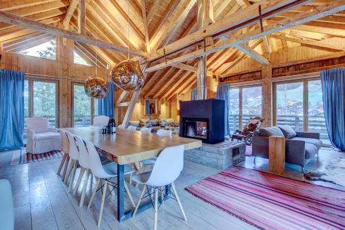 - une salle à manger et un salon avec une table et une cheminée dans l'établissement Auberge Duplex, à Morzine