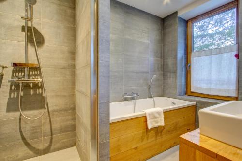 Un baño con ducha, bañera y lavabo. en Auberge Duplex, en Morzine