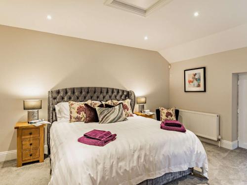 ein Schlafzimmer mit einem großen Bett mit lila Handtüchern darauf in der Unterkunft 3 Bed in Tollerton 87290 in Tollerton