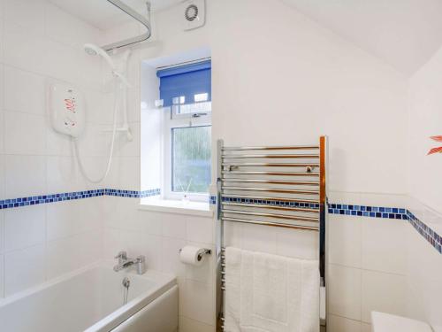 La salle de bains blanche est pourvue d'une baignoire et d'une douche. dans l'établissement 2 Bed in Kettlewell 87598, à Kettlewell