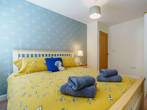 a bedroom with a yellow bed with blue walls at 2 Bed in Thirsk 87460 in South Kilvington