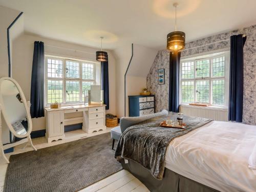 um quarto com uma cama, uma secretária e janelas em 2 Bed in Londesborough 88620 em Londesborough