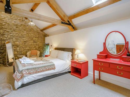 a bedroom with a bed and a red dresser and a mirror at 2 bed in Cowbridge 88000 