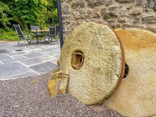 a large rock sitting next to a stone wall at 2 bed in Cowbridge 88000 in Llandow