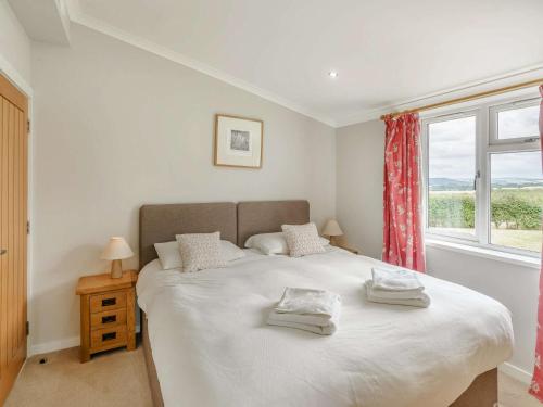 a bedroom with a large bed with a window at 3 Bed in St Andrews 88420 in Balmullo