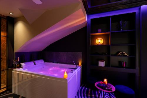 a bath tub with purple lighting in a room at Le Côté Secret in Vannes