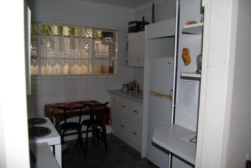 a kitchen with a white refrigerator and a table at Stop-a-While in Krugersdorp