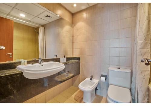 uma casa de banho com um lavatório e um WC em Amazing 3BR Apartment next to Emirates Towers Metro in DIFC em Dubai