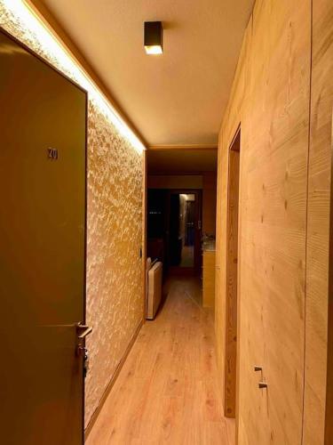 pasillo de una habitación con puerta y suelo de madera en Grazioso appartamento a Madonna di Campiglio, en Madonna di Campiglio