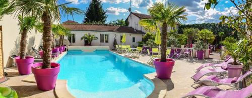 - une piscine bordée de palmiers et de chaises violettes dans l'établissement Manoir François 1er, à Vitry-le-François