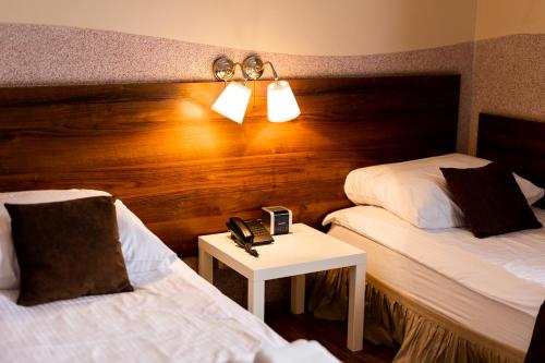 a hotel room with two beds and a table with a phone at Hotel Nevada in Łagów