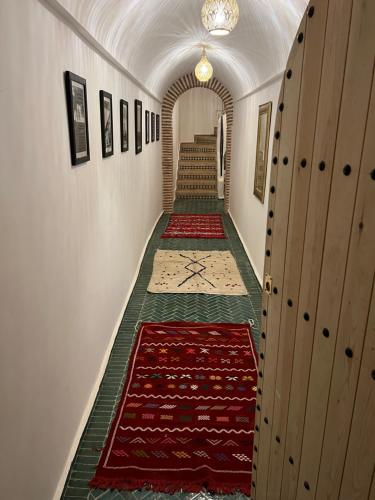 a hallway with carpets on the walls and stairs at Riad Darchica in Marrakech