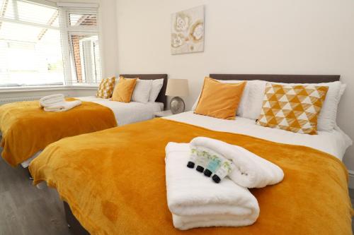 two beds with towels on them in a bedroom at Eastbourne Beautiful Seafront house in Eastbourne