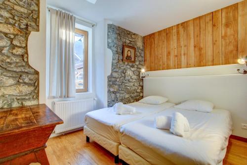 モルジヌにあるAuberge RDCの石壁のベッドルーム1室(ベッド2台付)