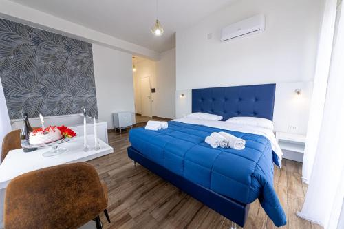 a bedroom with a blue bed and a table at Nel Cuore di Parthenope in Naples