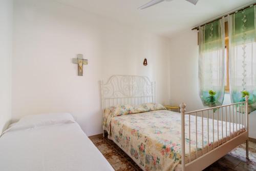 - une chambre avec un lit et une croix sur le mur dans l'établissement Villa letizia Baia del sol, à Porto Cesareo