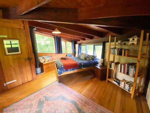 a bedroom with a bed and a book shelf at Summer Paradise at the Valley Farm House in Healesville